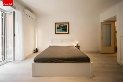 a bedroom with a bed in a white room at GuestHost - La finestra sui palazzi di Roma Apartment in Rome