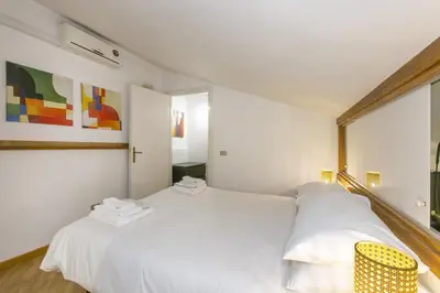 a bedroom with a white bed and a yellow chair at Trevi Little Palace #9 in Rome