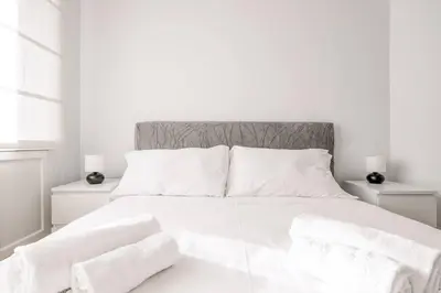 a white bedroom with a large white bed with white pillows at Vatican Museum Apartment - ZENO 26 in Rome