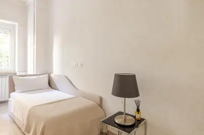 a bedroom with a bed and a lamp on a table at Casa Caterina - Modern design apartment near Vatican City in Rome