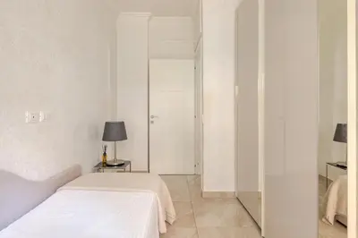 a white bedroom with a bed and a lamp at Casa Caterina - Modern design apartment near Vatican City in Rome
