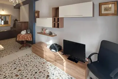 a living room with a flat screen tv and a chair at Tra le antiche mura e Garbatella in Rome