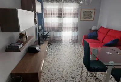 a living room with a red couch and a table at Tra le antiche mura e Garbatella in Rome