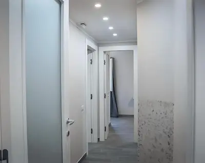 a hallway with white walls and white doors at Rome Essence Apartament in Rome
