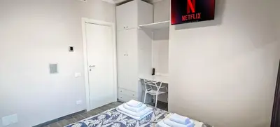 a room with white walls and a bed with towels at Rome Essence Apartament in Rome