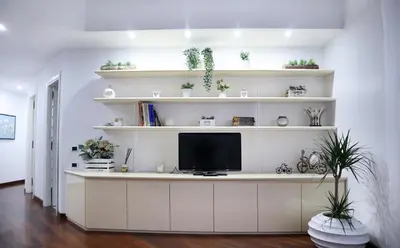 a living room with a tv on a white shelf at Cozy Home San Giovanni in Rome