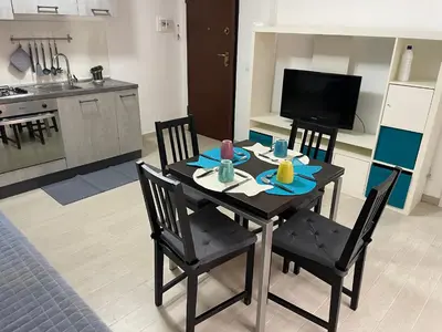 a dining room table with two chairs and a kitchen at BORGO PESCI in Rome