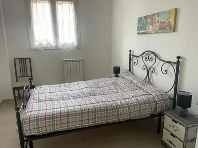 a bedroom with a bed with a plaid blanket and two windows at BORGO PESCI in Rome