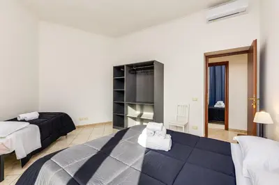 a hotel room with two beds and a television at Magenta Tiburtino in Rome