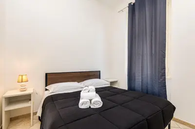 a bedroom with a large black bed with towels on it at Magenta Tiburtino in Rome
