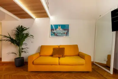 a yellow couch in a living room with a plant at Trevi Apartment in Rome