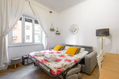 a bedroom with a bed with yellow pillows and a window at Appartamento Barsanti in Rome