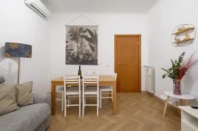a living room with a table and chairs and a couch at Appartamento Barsanti in Rome