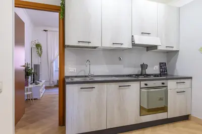 a kitchen with white cabinets and a sink at Appartamento Barsanti in Rome
