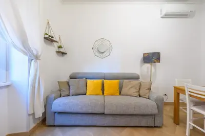 a couch with two yellow pillows in a living room at Appartamento Barsanti in Rome