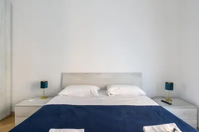 a bedroom with a large bed with two lamps at Appartamento Barsanti in Rome