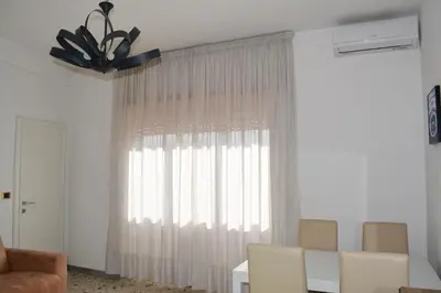a living room with a window with white curtains at La Casa di Dany in Rome