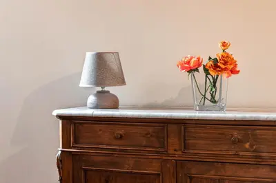 a vase of flowers and a lamp on a dresser at Dimora degli Acetari in Rome