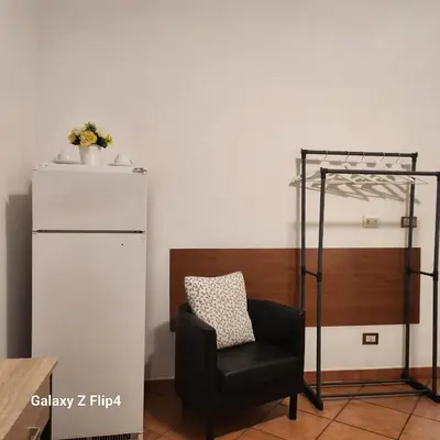 a black chair in a room with a refrigerator at SweetHouseVittorio in Rome