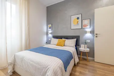 a bedroom with a bed with a blue and white blanket at BND Boutique Gemelli Vaticano in Rome