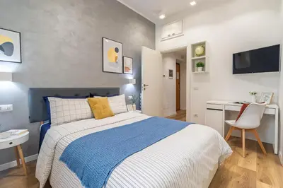 a bedroom with a blue and white bed and a desk at BND Boutique Gemelli Vaticano in Rome