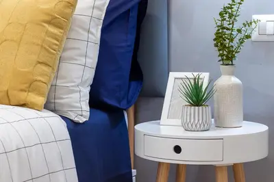 a side table with a vase on it next to a bed at BND Boutique Gemelli Vaticano in Rome