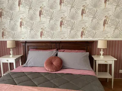 a bedroom with a bed with two tables and a wallpaper at Prope Vaticanum in Rome