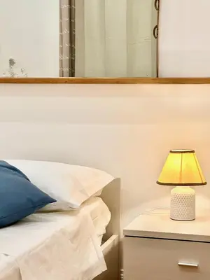 a lamp on a night stand next to a bed at Vacanze Romane Laterano in Rome