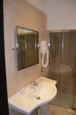 a bathroom with a sink and a shower with a mirror at Vaticano Royal Suite Guest House in Rome