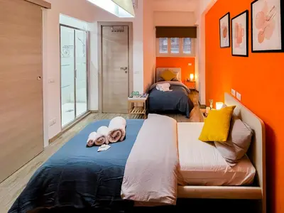 a bedroom with orange walls and a bed with towels on it at LE TRIPLETTE in Rome