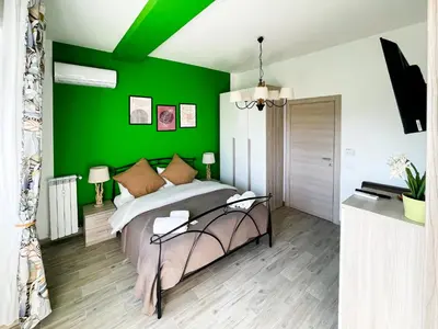 a bedroom with a green accent wall and a bed at LE TRIPLETTE in Rome