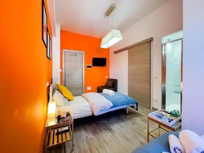 a bedroom with orange walls and a bed in a room at LE TRIPLETTE in Rome