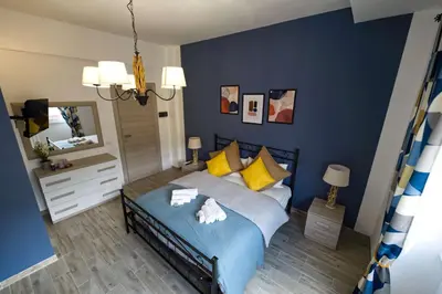 a bedroom with a bed with blue walls and yellow pillows at LE TRIPLETTE in Rome