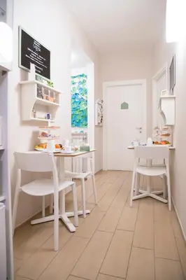 a room with white tables and chairs and a door at B&B Casetta Roma in Rome