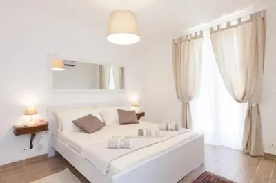a white bedroom with a large bed and a window at Casa Micheli in Centro ex Frattina Luxury Apartment in Rome