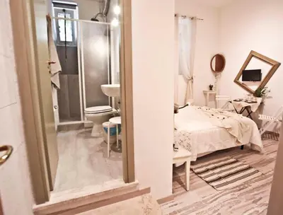 a bathroom with a bed and a sink and a mirror at SottosopraSannio in Rome