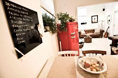a room with a table and a red refrigerator at SottosopraSannio in Rome