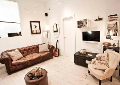 a living room with a brown couch and a chair at SottosopraSannio in Rome