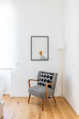 a chair in a living room with a picture on the wall at Little Gaia Suite in Rome