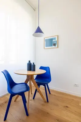 a table and two blue chairs in a room at Little Gaia Suite in Rome