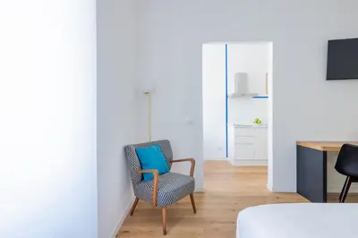 a room with a chair with a blue pillow at Little Gaia Suite in Rome