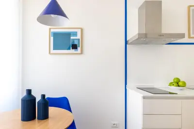 a kitchen with a table and a blue chair at Little Gaia Suite in Rome