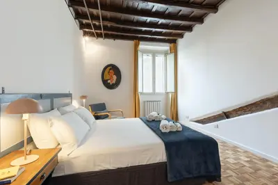 a bedroom with a large white bed and a desk at Rome As You Feel - Santa Margherita Design Apartment in Rome