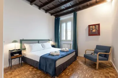 a bedroom with a bed and a blue chair at Rome As You Feel - Santa Margherita Design Apartment in Rome