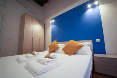 a bedroom with a blue wall and a bed with towels at Residenza Bernini in Rome