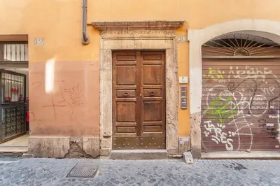 a wooden door on the side of a building with graffiti at ANTICA DIMORA FARNESE in Rome