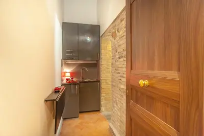a small kitchen with a refrigerator and a door at ANTICA DIMORA FARNESE in Rome