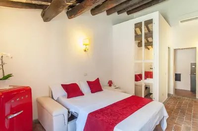 a bedroom with a white bed with red pillows at ANTICA DIMORA FARNESE in Rome