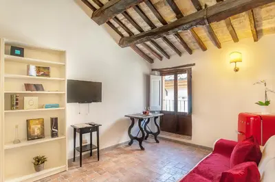 a living room with a red couch and a tv at ANTICA DIMORA FARNESE in Rome