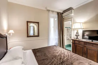 a bedroom with a bed and a mirror and a television at Aurelius Ponte Sant'Angelo in Rome